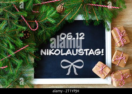 16 octobre 2023 : Happy St. Nicholas Day salutation sur un tableau noir à côté de branches de sapin et de petits cadeaux. Sur la 06,12 se trouve St. Nicholas PHOTOMONTAGE *** Schönen Nikolaustag Gruß auf einer Tafel neben Tannenzweigen und kleinen Geschenken. AM 06,12 ist Nikolaus FOTOMONTAGE crédit : Imago/Alamy Live News Banque D'Images