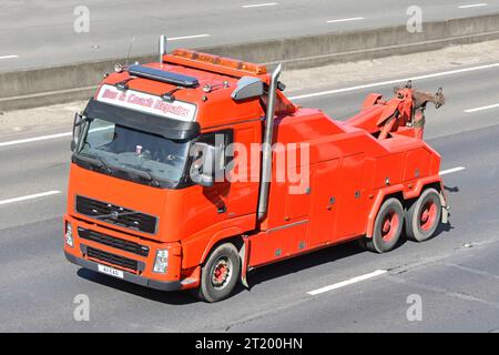 Regardant vers le bas sur la peinture rouge propre non marquée sur bus et autocar Volvo hgv camion une entreprise de dépannage de remorquage de véhicule commercial sur l'autoroute M25 UK Banque D'Images