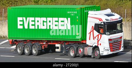 EVERGREEN marque de conteneur d'expédition sur semi-remorque remorqué par l'entreprise de transport blanc DAF prime Mover hgv camion roulant sur la route d'autoroute M25 UK Banque D'Images