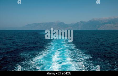 sillage blanc de bateau, mousse de lavage de prop sur la texture de fond de mer bleu. Éclaboussures d'eau profonde ondulée et ondulée derrière le navire. Espace Banque D'Images