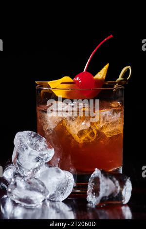 cocktail negroni élégant sophistiqué avec cerise et glace sur fond noir, concept Banque D'Images