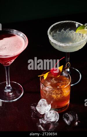 rafraîchissant margarita, cosmopolite et negroni avec des glaçons sur fond noir, concept Banque D'Images