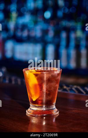 superbe mai tai zesty dans un verre lowball avec une tranche de citron et de la glace avec un bar en toile de fond, concept Banque D'Images