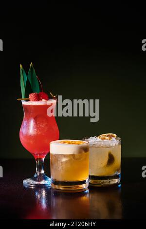 caipirinha tropicale et singapore sling, whisky élégant aigre sur fond noir, concept Banque D'Images