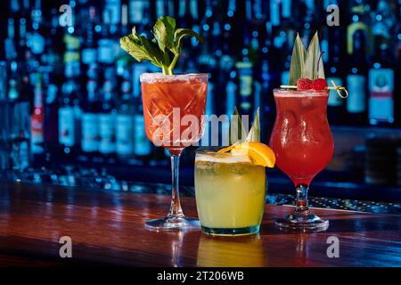 verres de trois cocktails rafraîchissants différents avec des décorations sur le comptoir de bar, concept Banque D'Images