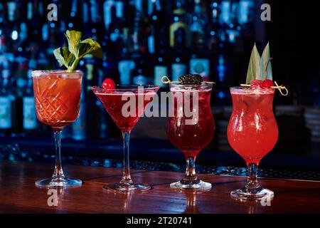 ensemble rafraîchissant de quatre cocktails avec garnitures sur le comptoir avec fond de bar, concept Banque D'Images
