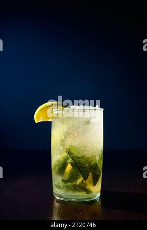 verre rafraîchissant de mojito garni de tranches de menthe et de citron vert sur fond sombre, concept Banque D'Images