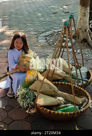 Petite fille avec des fleurs sur Phan Dinh Phung Street, Hanoi, Vietnam Banque D'Images