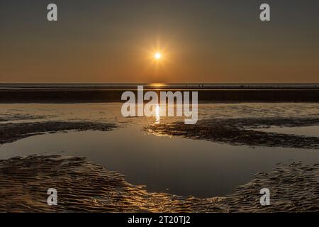 Vue sur la plage de Formby à marée basse, avec le soleil couchant sur la mer Banque D'Images