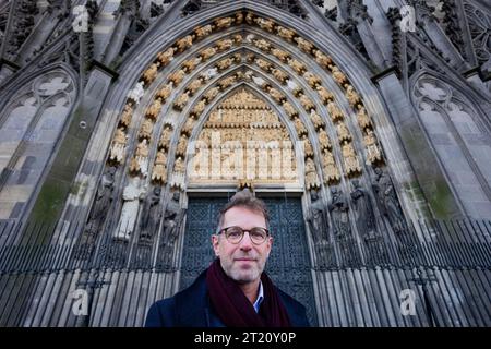 Cologne, Allemagne. 16 octobre 2023. L'architecte de la cathédrale Peter Füssenich se tient devant la cathédrale restaurée St. Portail de Michael à la cathédrale de Cologne. Une tête de sculpture de la cathédrale de Cologne qui a été abattue à la fin de la Seconde Guerre mondiale est revenue après plus de 70 ans. Crédit : Rolf Vennenbernd/dpa/Alamy Live News Banque D'Images