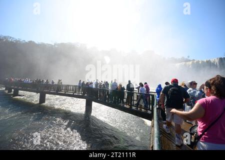 Touristes avec imperméables aux chutes d'Iguaçu, avec jet d'eau des cascades en vue panoramique Banque D'Images