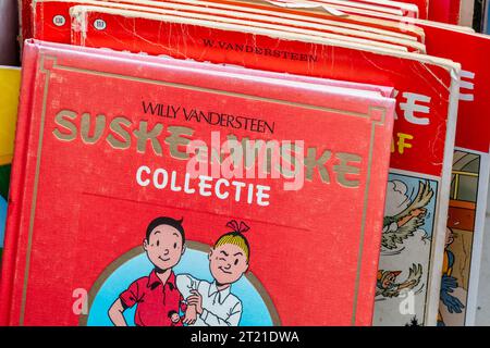 Rheden, pays-Bas - 13 août 2023 : pile de vieilles bandes dessinées de la série rouge néerlandaise de Suske en Wiske, en anglais : Spike et Suzy, sur une fai antique Banque D'Images
