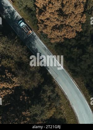 Un camion rouge roule sur une route de campagne sinueuse Banque D'Images