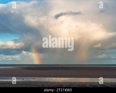 Arc-en-ciel et nuages de douche dégageant Poolbeg Beach et Sandymount Strand Banque D'Images