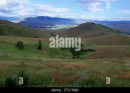 Vue panoramique des montagnes et des vallées couvertes de prairies avec rivière à distance ; nuages éparpillés dans le ciel avec des ombres sur la terre. Sujets : montagnes ; paysages ; Vallées ; refuges pour animaux sauvages. Localisation : Montana. Site du Fish and Wildlife Service : National Bison Range. Collection : refuges fauniques.. 1998 - 2011. Banque D'Images