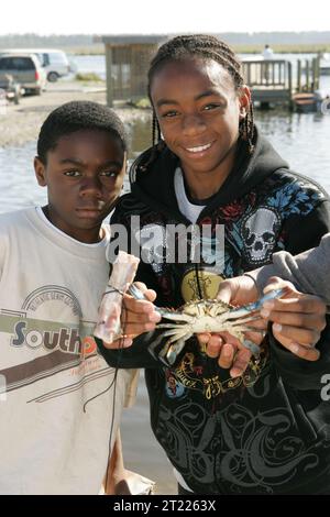 Deux jeunes garçons montrent fièrement le crabe bleu qu'ils ont attrapé!. Sujets : environnements aquatiques ; enfants ; environnements côtiers ; connecter les gens à la nature ; crustacés ; pêche ; activités de loisirs ; environnements marins; loisirs ; refuges pour animaux sauvages. Localisation : Louisiane. Site du service des poissons et de la faune : REFUGE FAUNIQUE NATIONAL DE BIG BRANCH MARSH. . 1998 - 2011. Banque D'Images