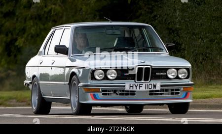 Bicester,Oxon.,UK - Oct 8th 2023 : 1980 bleu BMW série 5 M 535i voiture classique conduisant sur une route de campagne anglaise. Banque D'Images