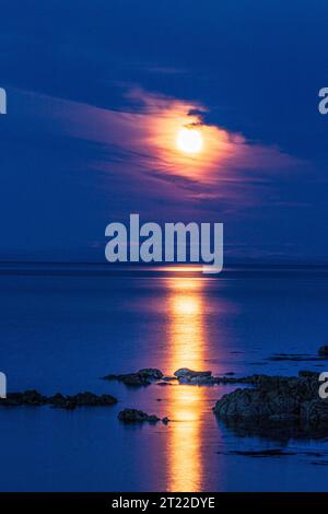 La super lune (une lune bleue) le 30/8/2023 se levant au-dessus de l'île d'Arran vue depuis la péninsule de Kintyre, Écosse Royaume-Uni Banque D'Images