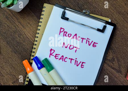 Concept d'écriture proactive et non réactive sur la paperasse isolée sur la table en bois. Banque D'Images