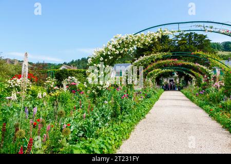 Arches roses et bordures fleuries colorées d'été à Giverny, le jardin du peintre impressionniste français Claude Monet, Normandie, nord de la France Banque D'Images