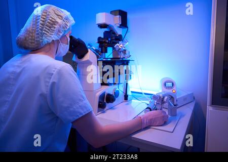 Femme scientifique expérimentée effectuant la procédure ICSI en laboratoire Banque D'Images