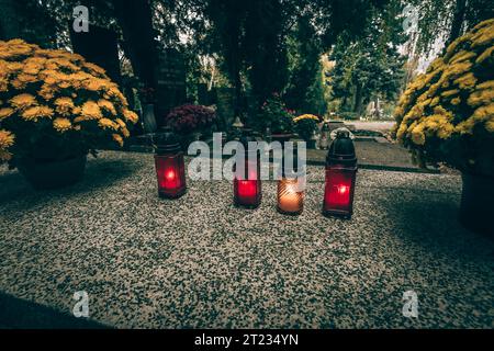 Fête de toutes les âmes dans le cimetière, décoration chrétienne traditionnelle sur pierre tombale, bougies, lanternes, fleurs Banque D'Images