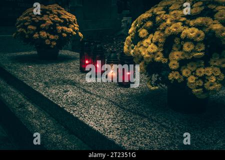 Fête de toutes les âmes dans le cimetière, décoration chrétienne traditionnelle sur pierre tombale, bougies, lanternes, fleurs Banque D'Images