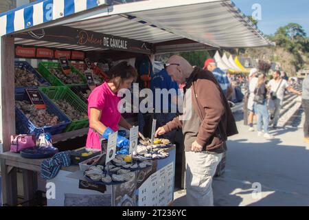 France, Bretagne, Cancale : un client choisit des huîtres chez un vendeur de rue. Banque D'Images