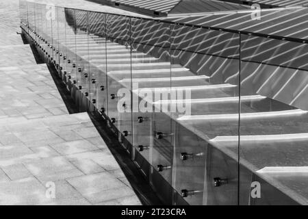 Perspective d'un toit brillant, mains courantes et escalier en pierre descendant. Photo de fond d'architecture moderne abstraite. Photo noir et blanc Banque D'Images