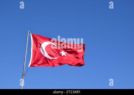 Agitant le drapeau turc ou le drapeau de la Turquie sur le ciel bleu. Banque D'Images