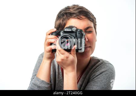 Jeune femme photographe avec appareil photo numérique Nikon Banque D'Images