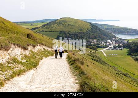 Lulworth Cove chemin côtier sud-ouest, couple de personnes âgées marchant vers la descente raide de Lulworth Cove, Dorset, Angleterre, Royaume-Uni, septembre 2023 Banque D'Images