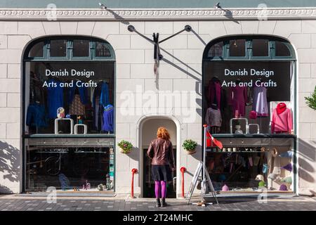 Femme regardant la vitrine d'un magasin à Copenhague Banque D'Images