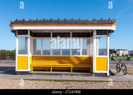 Abri traditionnel en bord de mer sur le front de mer Southsea, Portsmouth, Hampshire, Angleterre, Royaume-Uni, avec un cycliste homme assis et reposant Banque D'Images