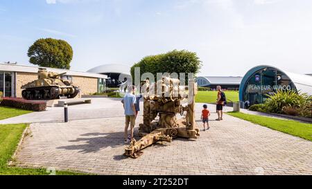 Les visiteurs observent un pistolet dans le parc du Musée Airborne de Sainte-mère-Eglise, consacré aux parachutistes américains au jour J. Banque D'Images