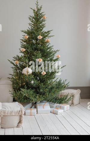 Sapin de Noël élégamment décoré avec des cadeaux de Noël dans une maison Banque D'Images
