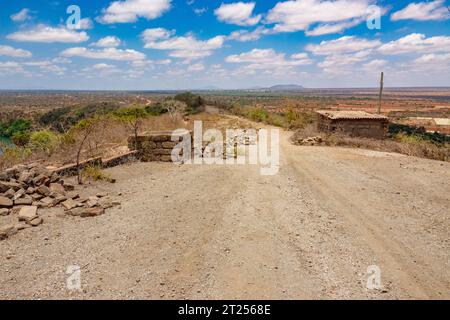 Vue panoramique d'un chemin de terre dans les paysages arides panoramiques de VOI, Kenya Banque D'Images