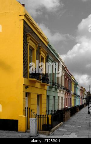 Maisons mitoyennes anglaises isolées de couleur à Londres sur un fond noir et blanc. Banque D'Images