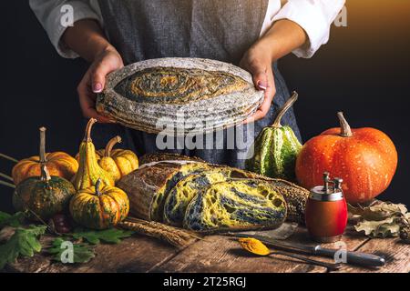 Four à pain au levain croustillant maison cuit et femme boulanger avec des aliments d'automne dans la cuisine Banque D'Images