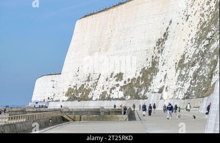 Brighton Royaume-Uni 17 octobre 2023 - calme avant que la tempête Babet arrive alors que les marcheurs profitent du soleil le long de la promenade sous la falaise à Saltdean près de Brighton. La tempête Babet devrait arriver en Grande-Bretagne à partir de demain apportant vents forts et fortes pluies : Credit Simon Dack / Alamy Live News Banque D'Images