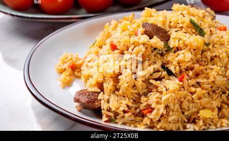 Délicieux pilaf avec de la viande servi sur une table en marbre blanc, gros plan Banque D'Images