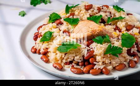 Crevettes poêlées et mélange de couscous, d'orzo, de haricots garbanzo et de quinoa rouge servis avec des pois verts et de l'oignon vert en gros plan sur une assiette sur fond blanc Banque D'Images