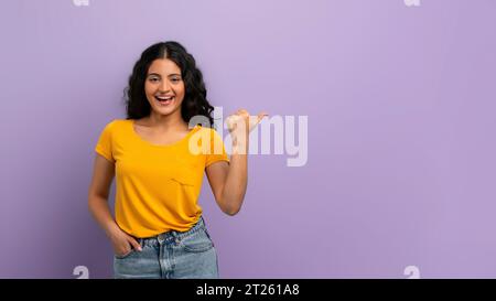 Joyeuse jeune femme indienne pointant vers l'espace de copie Banque D'Images