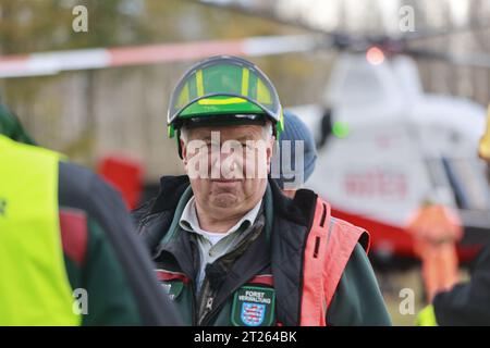 17 octobre 2023, Thuringe, Harztor/OT Ilfeld : le directeur des opérations Hennri Partsch, chef de VSG à ThüringenForst, se tient près de Netzkater dans le bureau forestier de Bleicherode-Südharz dans une zone de stockage de bois. Dans le cadre de l'obligation de sécurité routière le long de la route fédérale 81, plus de 100 arbres sont enlevés de la zone sur un terrain impraticable. À cette fin, une société spéciale de Suisse a été engagée pour transporter les arbres hors de la zone avec un hélicoptère. Photo : Matthias Bein/dpa Banque D'Images