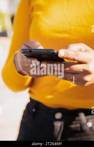 Photo verticale rapprochée des mains d'une jeune femme à l'aide d'un smartphone Banque D'Images