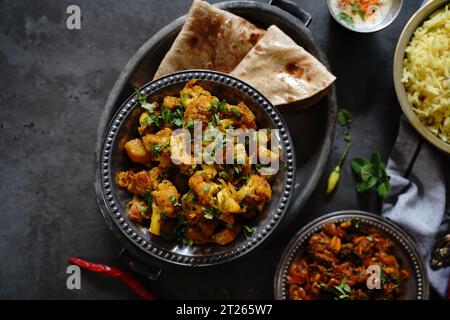 L'aloo Gobi fait maison est un curry végétarien indien composé de pommes de terre et de chou-fleur, servi avec du riz et des roti Banque D'Images