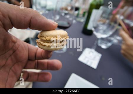 Main tenant un macaron de café sur les Bateaux Parisiens sur la seine Banque D'Images