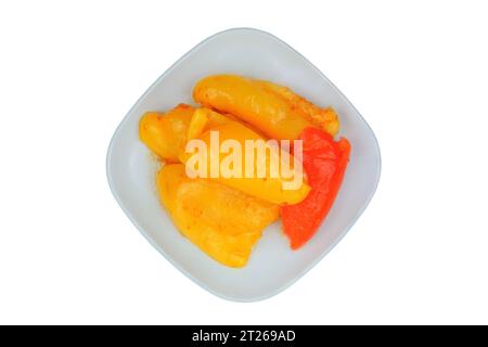 Poivre fermenté dans une assiette isolée sur fond blanc. Paprika mariné. Vue de dessus. Banque D'Images