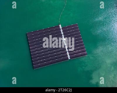 Vue aérienne de la ferme solaire flottante avec de nombreux panneaux solaires sur le lac turquoise Banque D'Images
