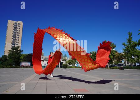 Comté de Luannan, Chine - 22 août 2023 : des rubans ondulés pour la performance sont exécutés sur une place. Banque D'Images